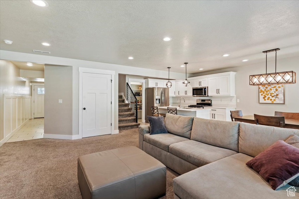 Living room with light carpet, stairway, and recessed lighting