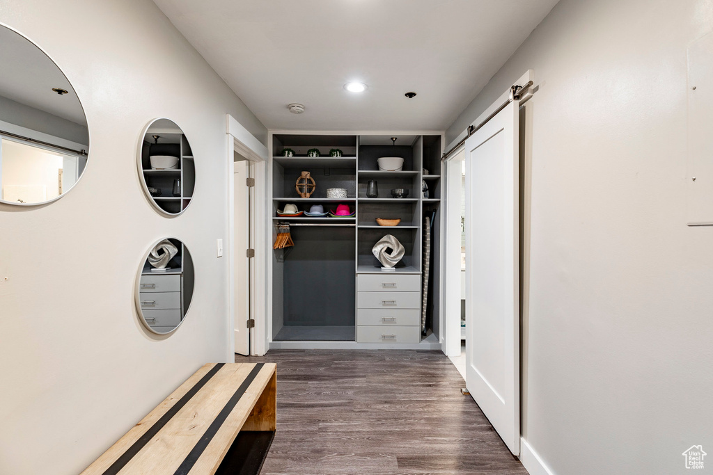 Hall with dark wood-style floors, a barn door, and recessed lighting