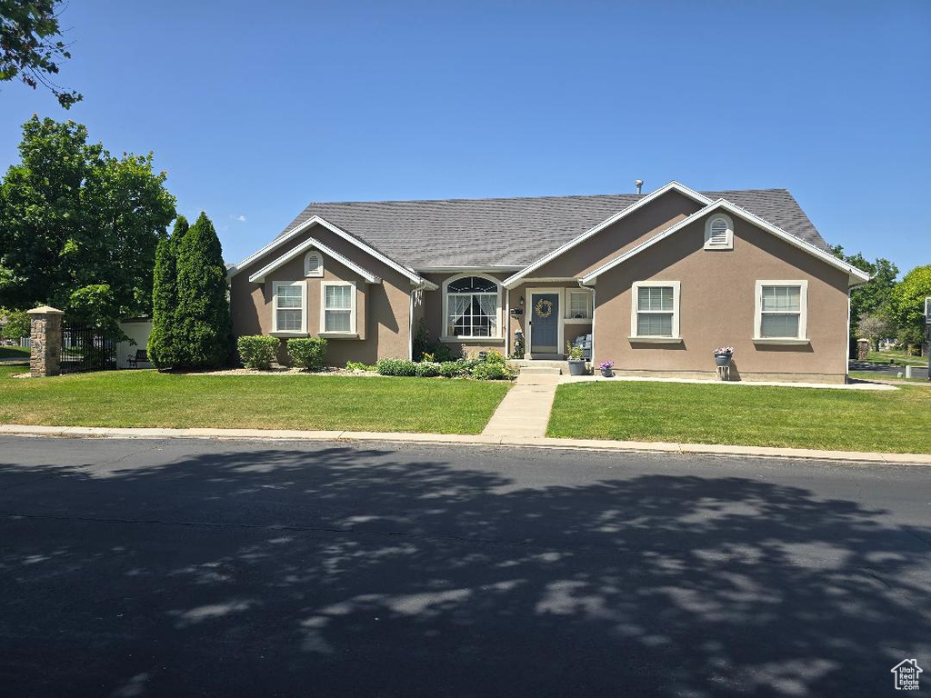 View of front of home with stucco siding and a front yard
