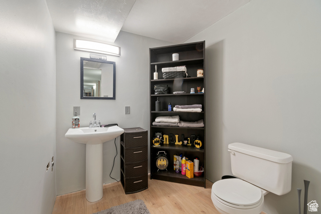 Bathroom with toilet and wood finished floors