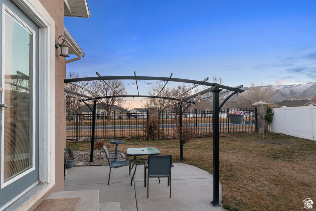 Patio terrace at dusk featuring a patio and a fenced backyard