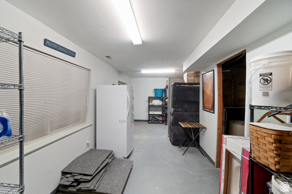 Kitchen featuring freestanding refrigerator and concrete floors