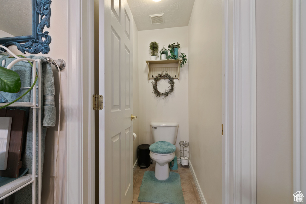 Bathroom with toilet and tile patterned flooring