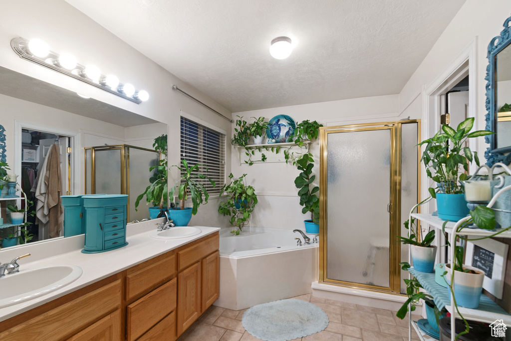 Bathroom featuring a shower stall, a garden tub, and double vanity