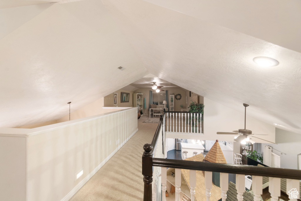 Corridor featuring lofted ceiling, an upstairs landing, and carpet