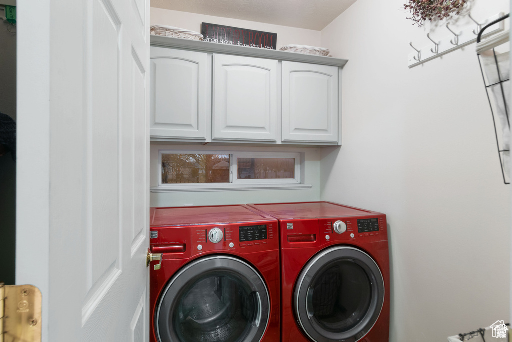 Washroom featuring independent washer and dryer and cabinet space