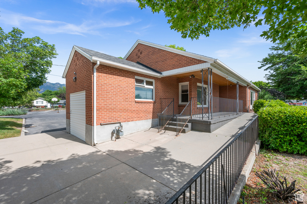 Back of property featuring brick siding, a porch, and a mountain view