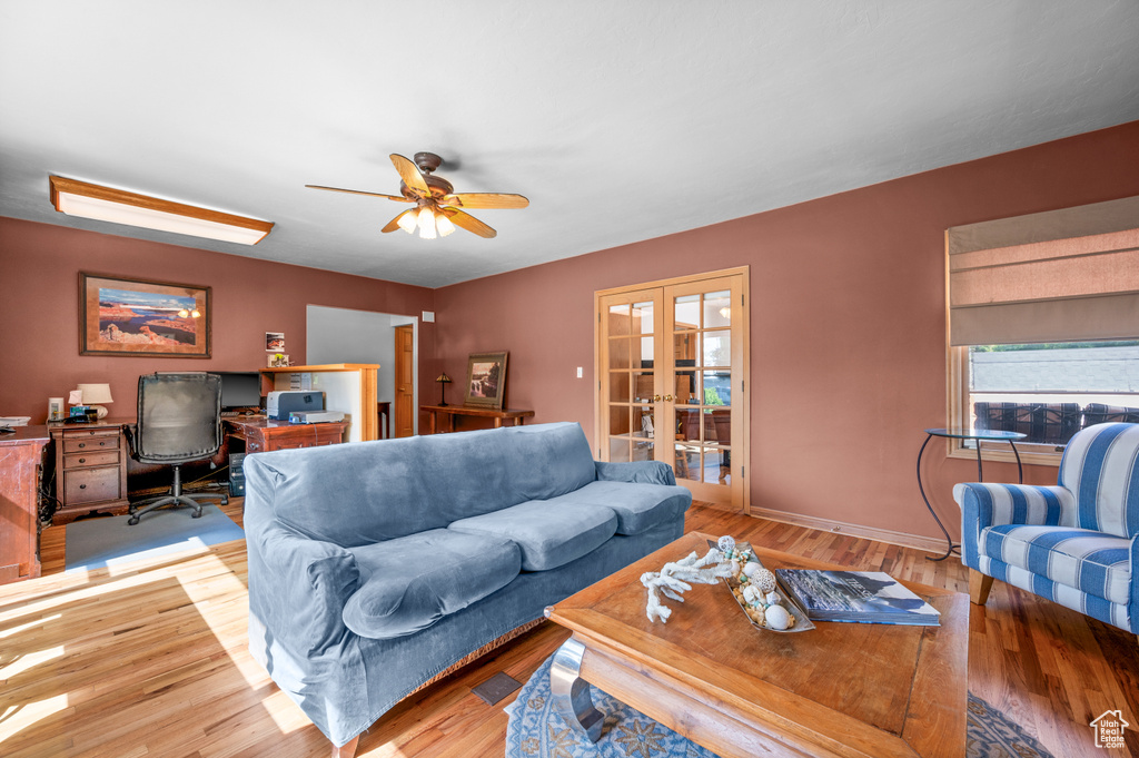 Living area with an office area, french doors, a ceiling fan, and wood finished floors
