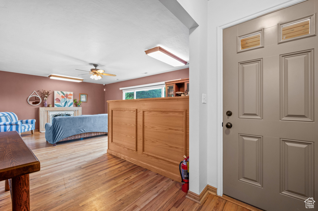 Foyer entrance with light wood finished floors and ceiling fan
