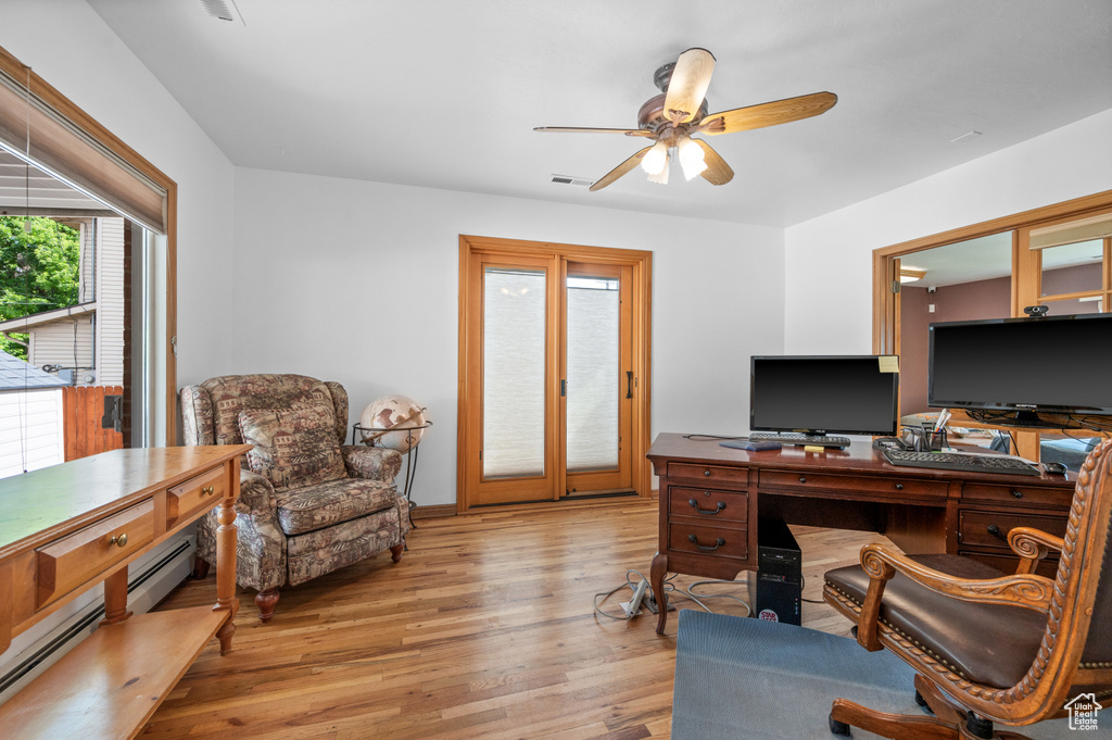 Office featuring ceiling fan, light wood-style flooring, and a baseboard heating unit