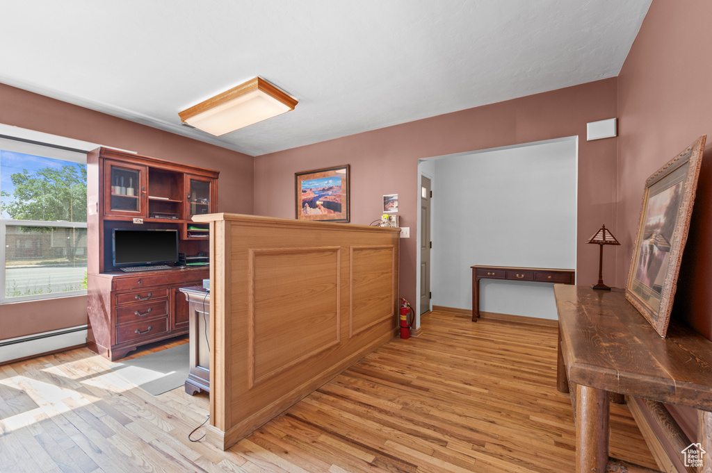 Corridor with light wood-style floors and baseboard heating