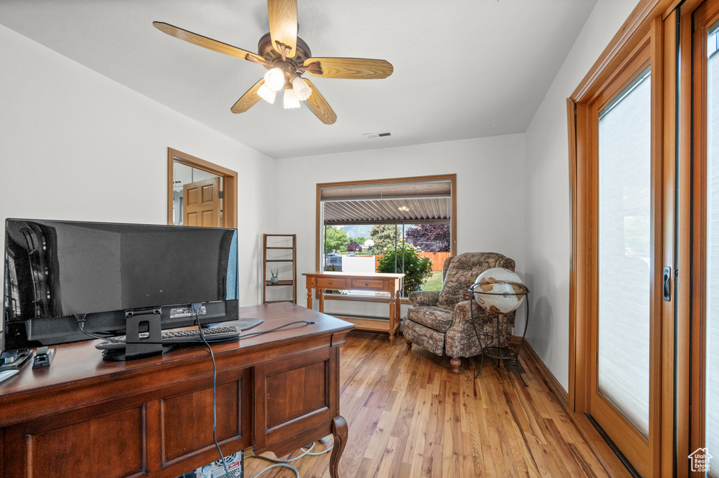 Office space with light wood-style flooring and ceiling fan