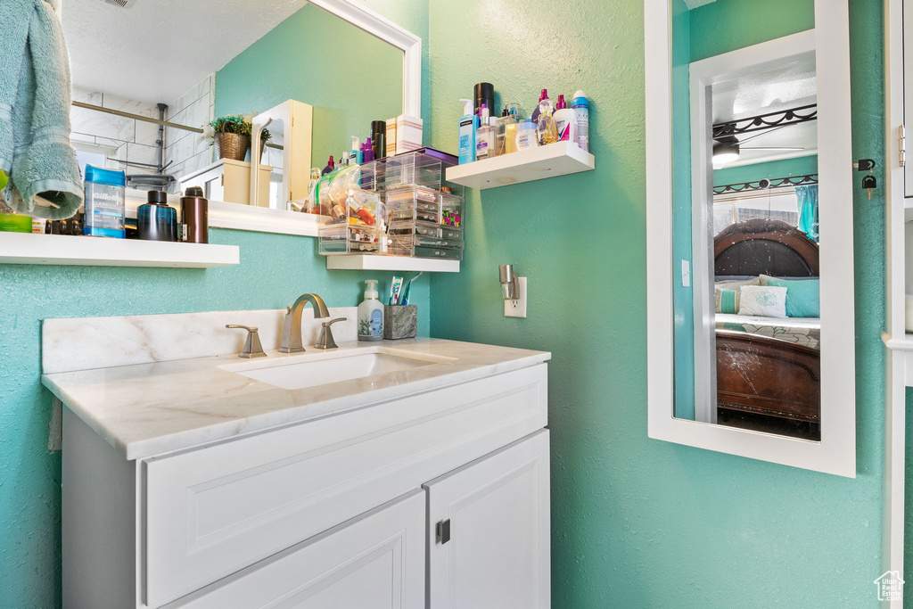 Bathroom with vanity and a textured wall