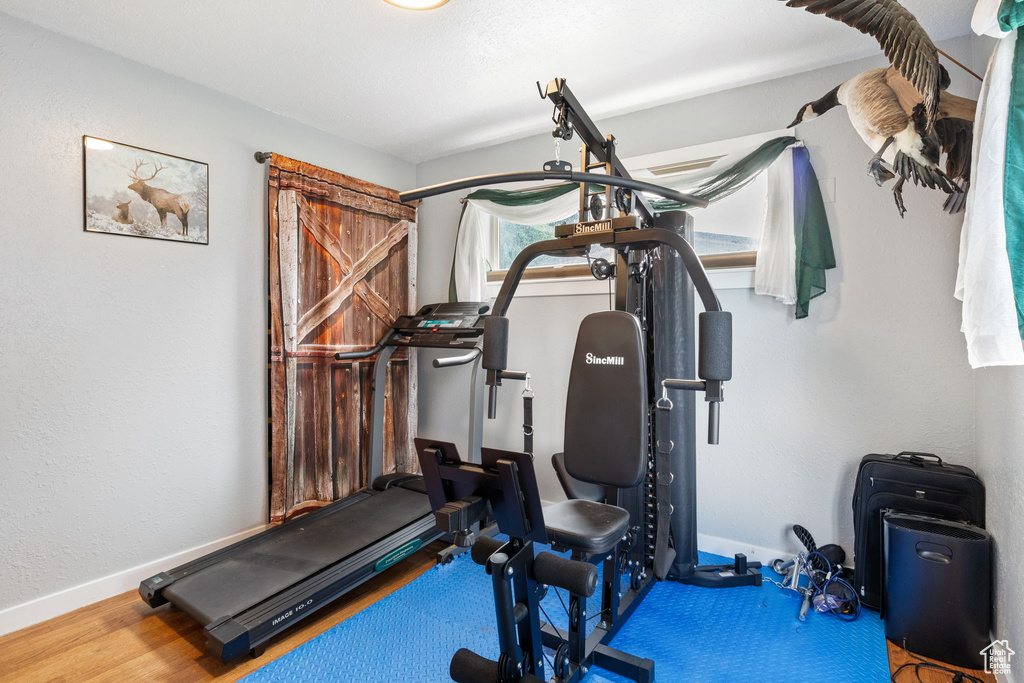 Exercise room with baseboards and wood finished floors