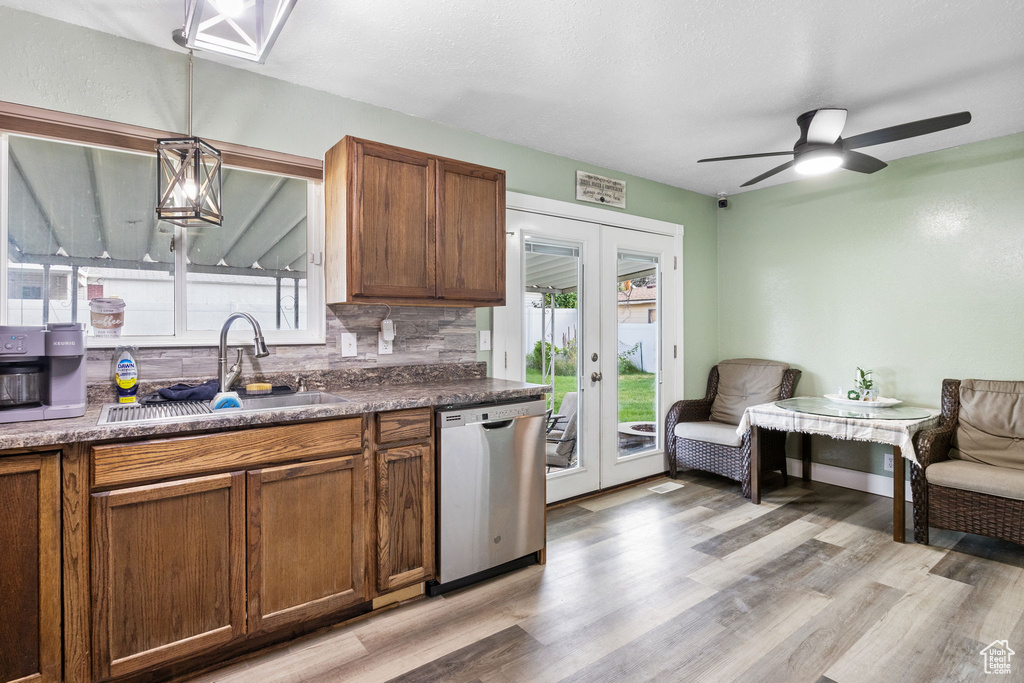 Kitchen featuring stainless steel dishwasher, french doors, tasteful backsplash, ceiling fan, and brown cabinetry