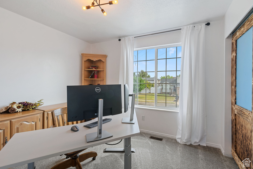 Office area with plenty of natural light and a chandelier