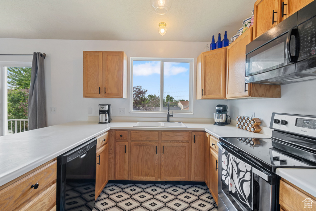 Kitchen with black appliances and light countertops