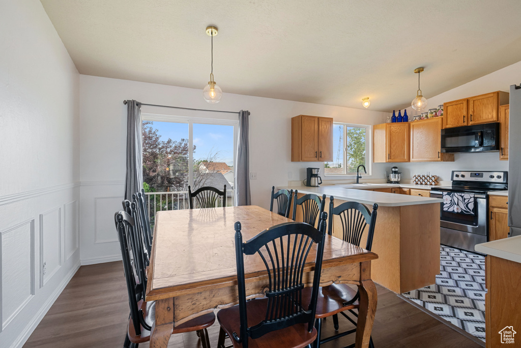 Dining area with dark wood-style flooring and wainscoting