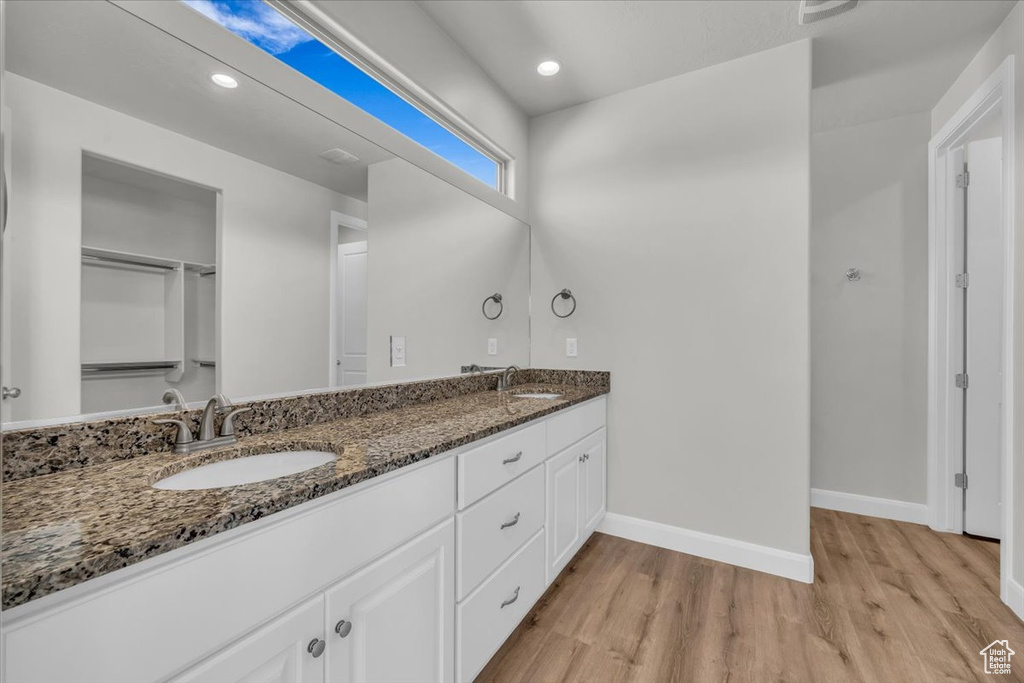 Full bathroom with wood finished floors, double vanity, and recessed lighting