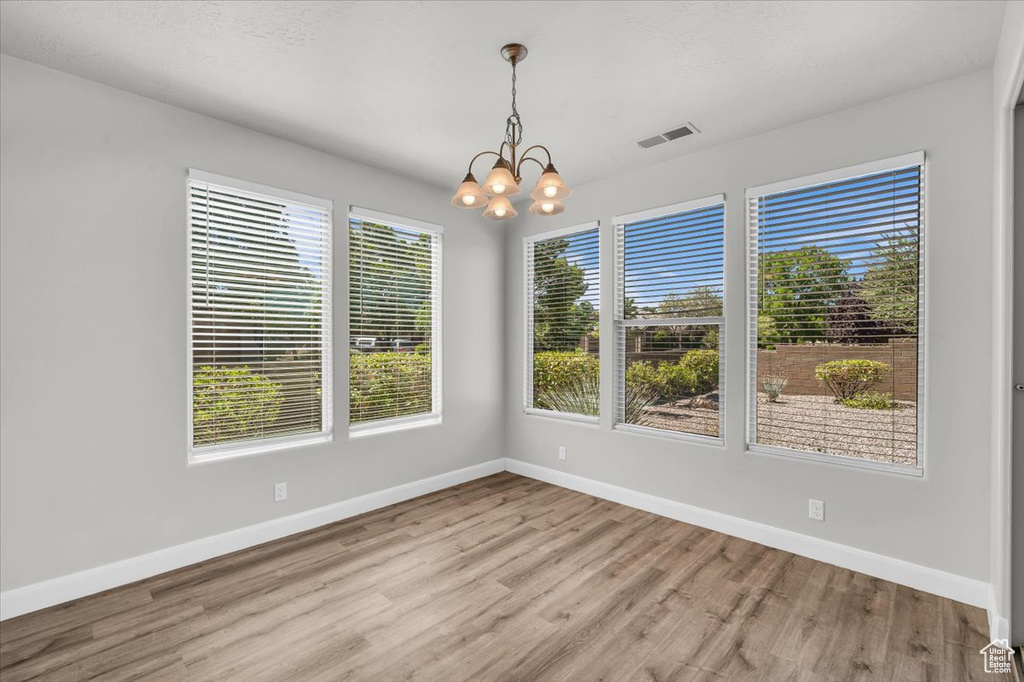 Unfurnished room with a chandelier and wood finished floors