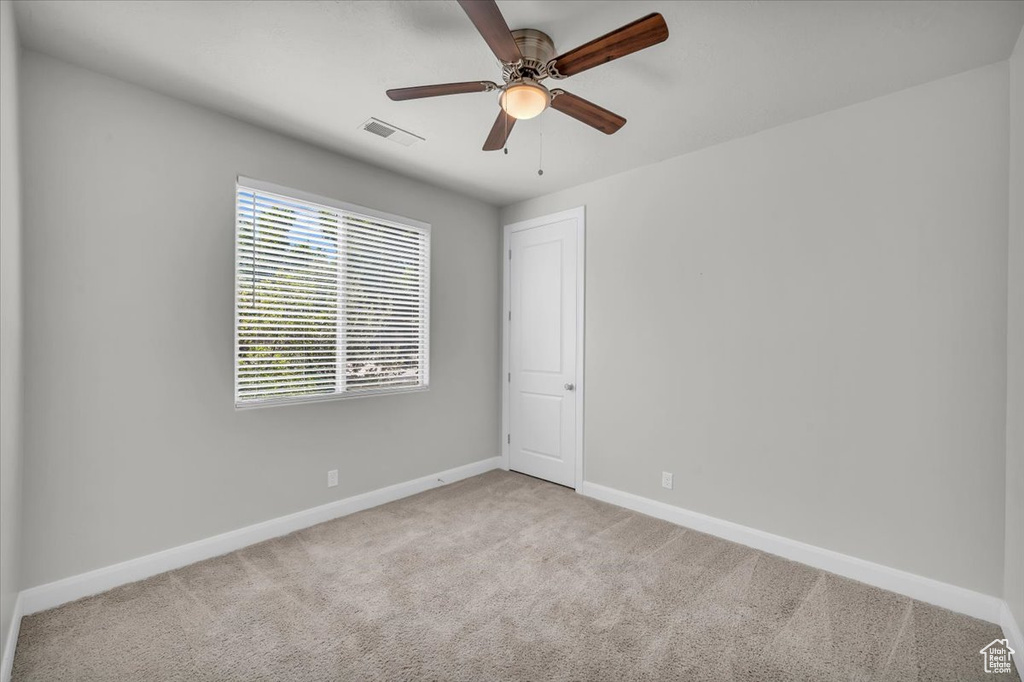 Spare room featuring ceiling fan and carpet floors