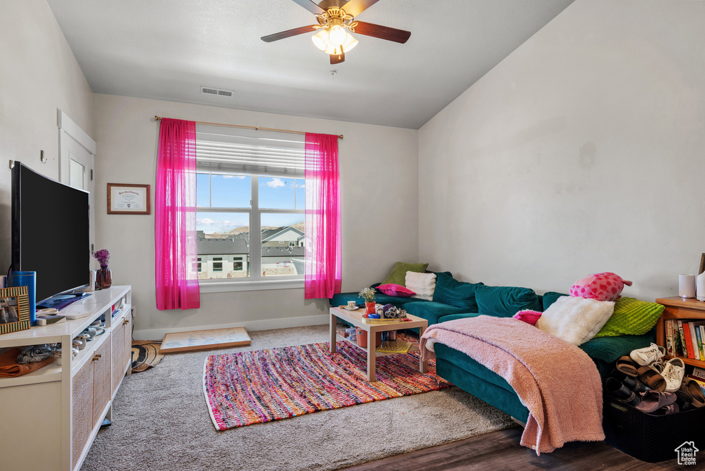Living room featuring a ceiling fan and lofted ceiling