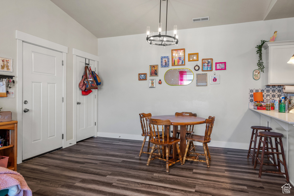 Dining space with dark wood-style floors and a chandelier