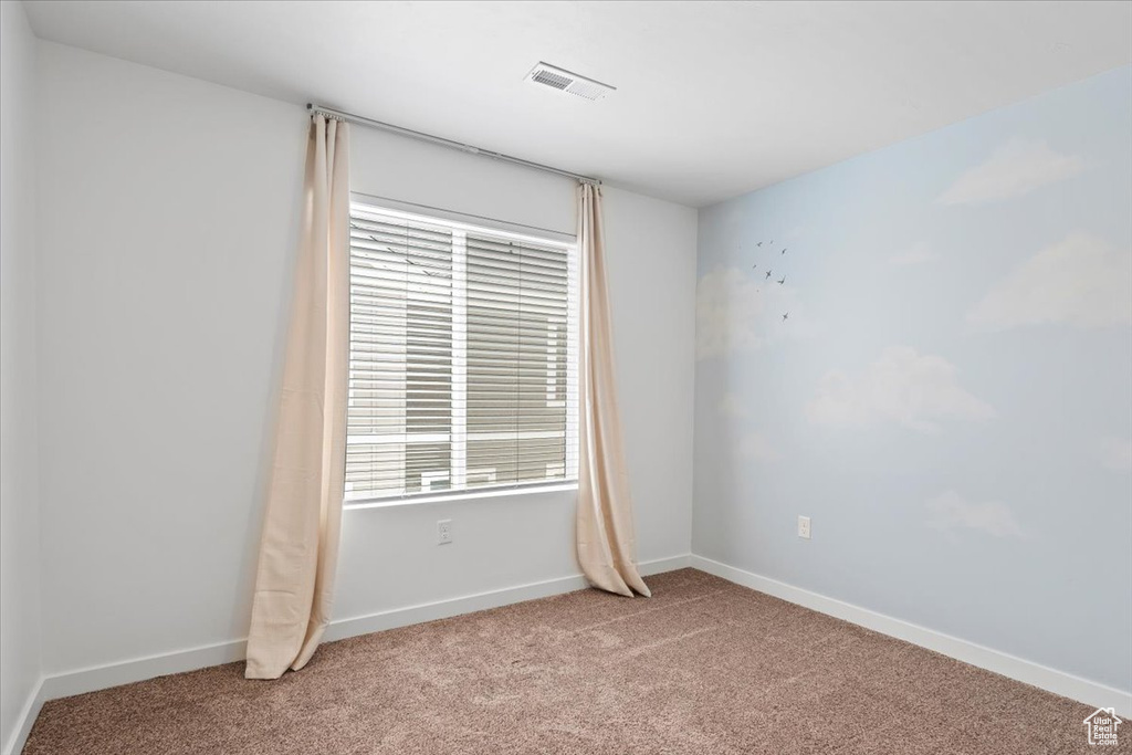 Unfurnished room with light colored carpet and baseboards