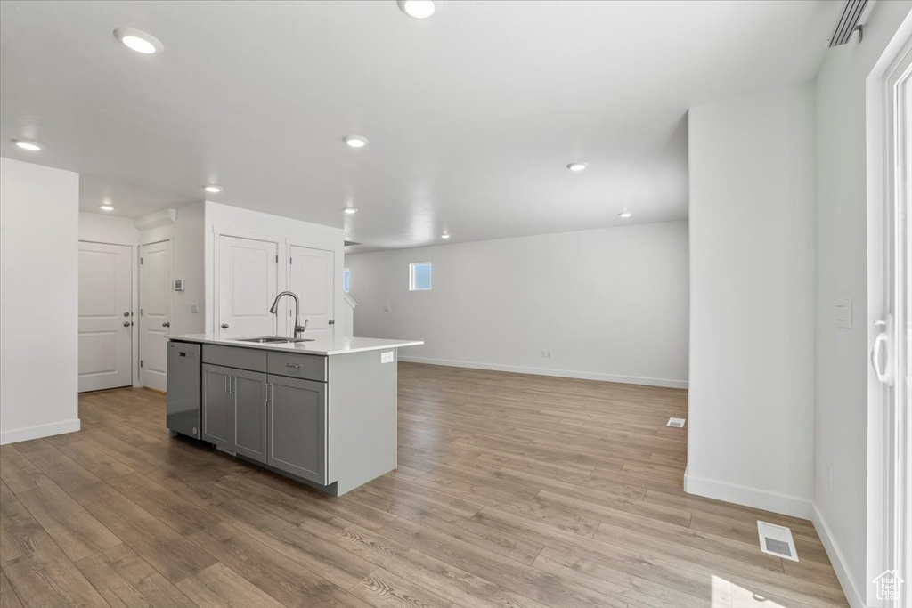 Kitchen featuring dishwasher, gray cabinets, light wood finished floors, recessed lighting, and light countertops