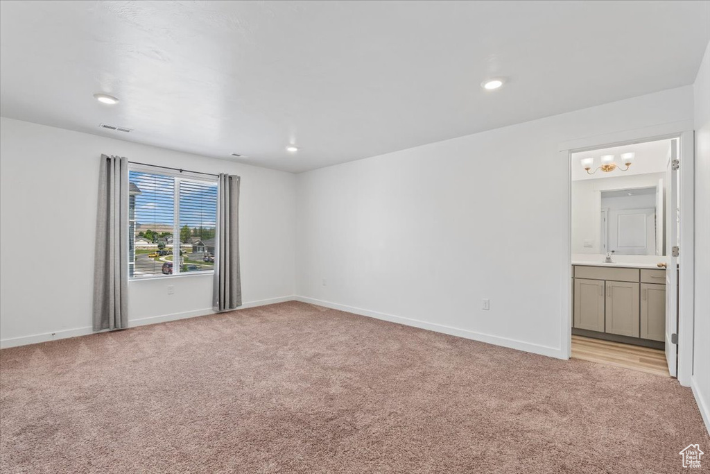 Unfurnished room featuring light carpet, a chandelier, and recessed lighting