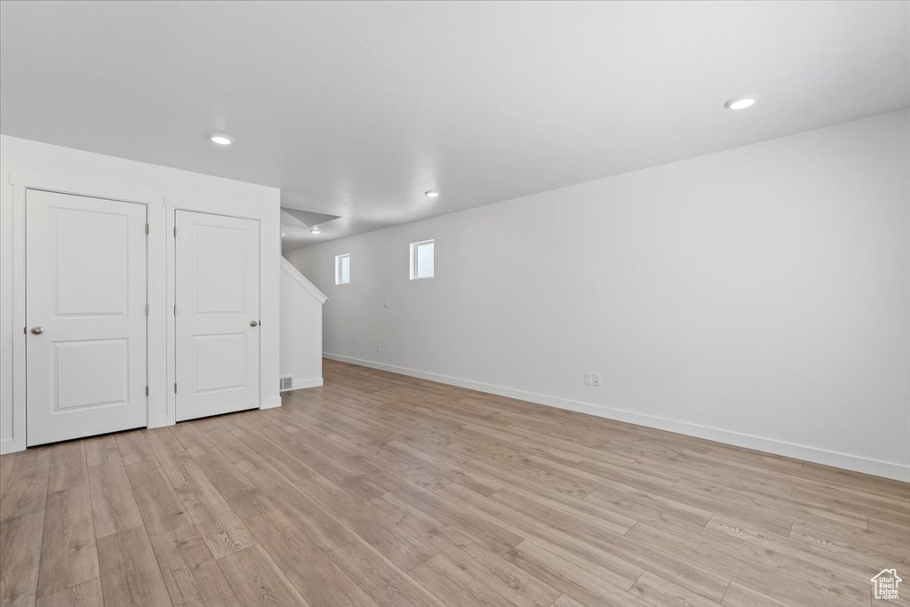 Basement with light wood finished floors and recessed lighting