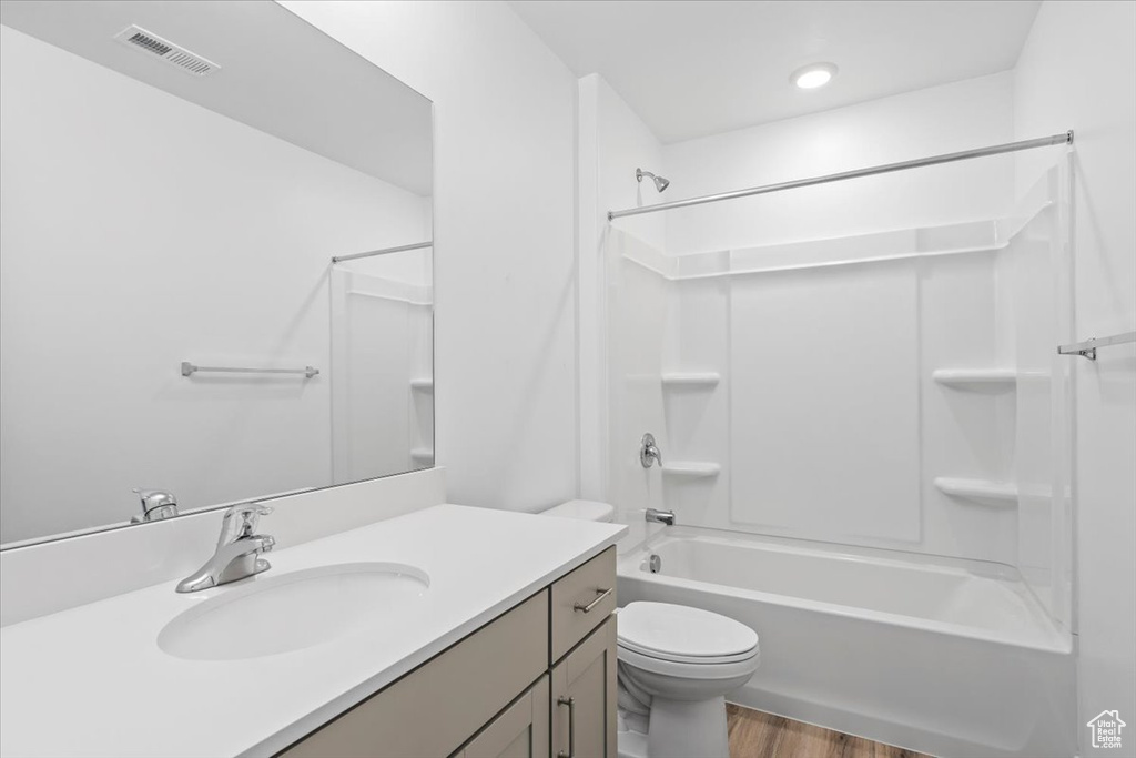 Bathroom with vanity, shower / washtub combination, and wood finished floors