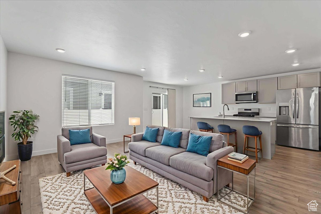 Living room with light wood-style floors and recessed lighting
