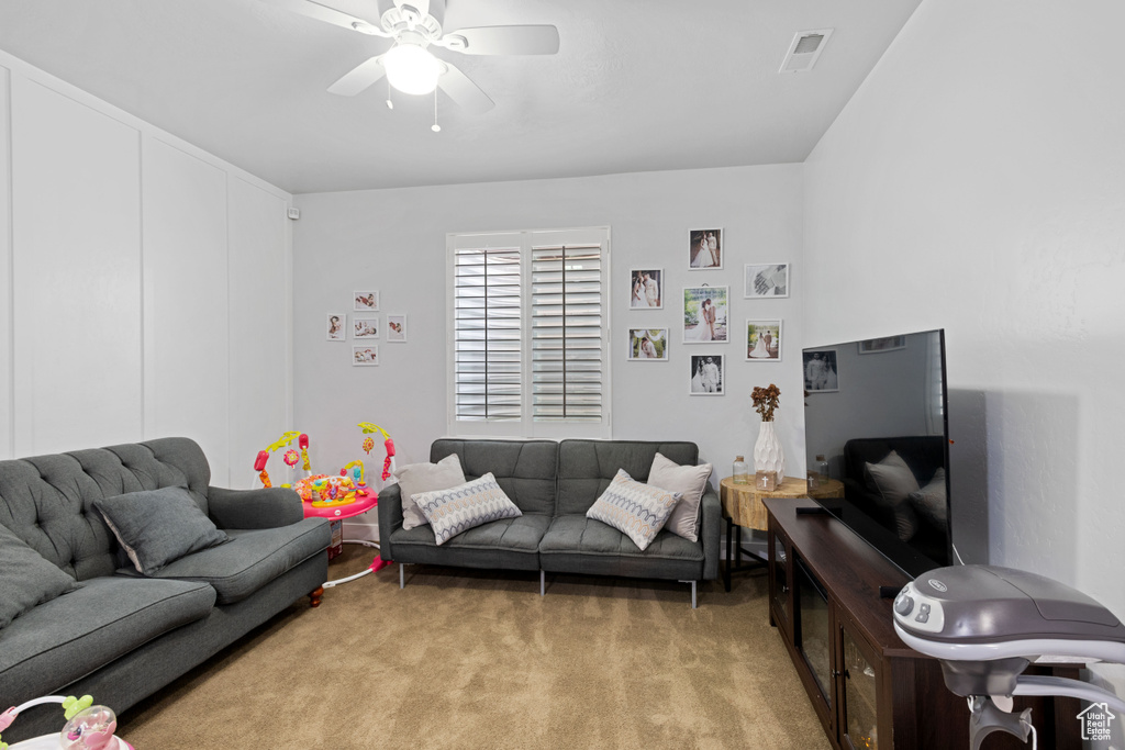 Living room featuring light colored carpet and ceiling fan