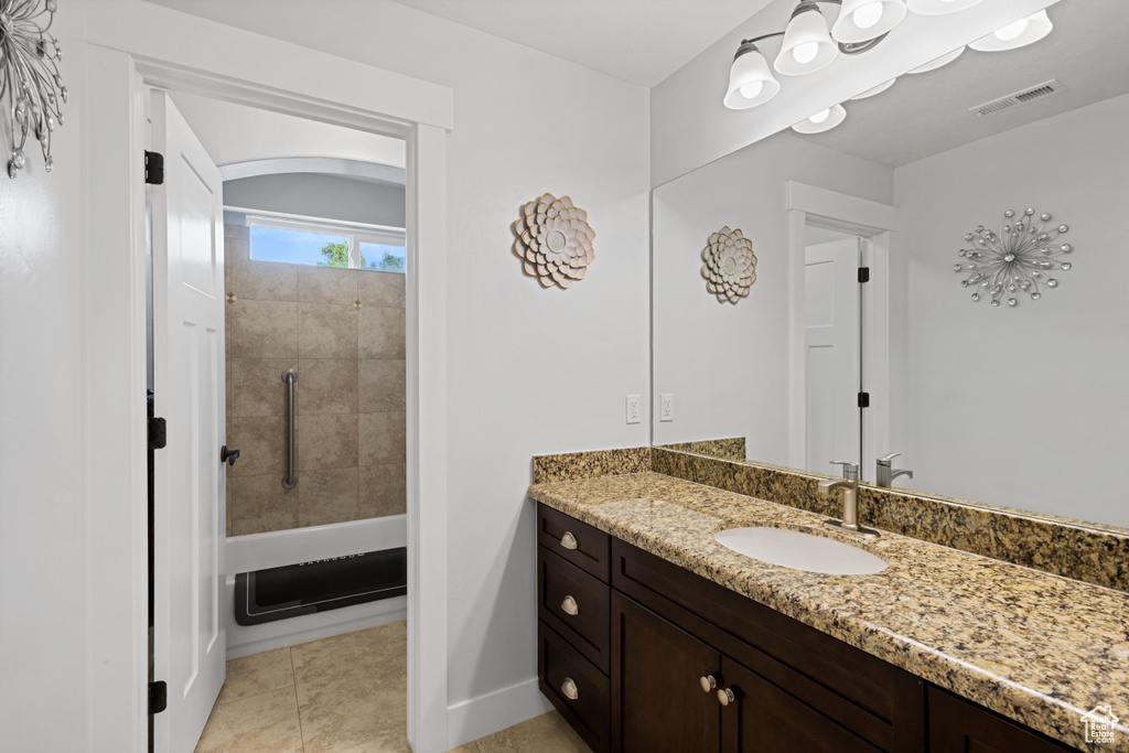 Bathroom featuring vanity, bathtub / shower combination, and tile patterned floors