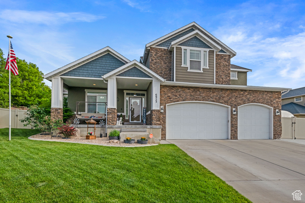 Craftsman house featuring a porch, stone siding, concrete driveway, a garage, and a gate