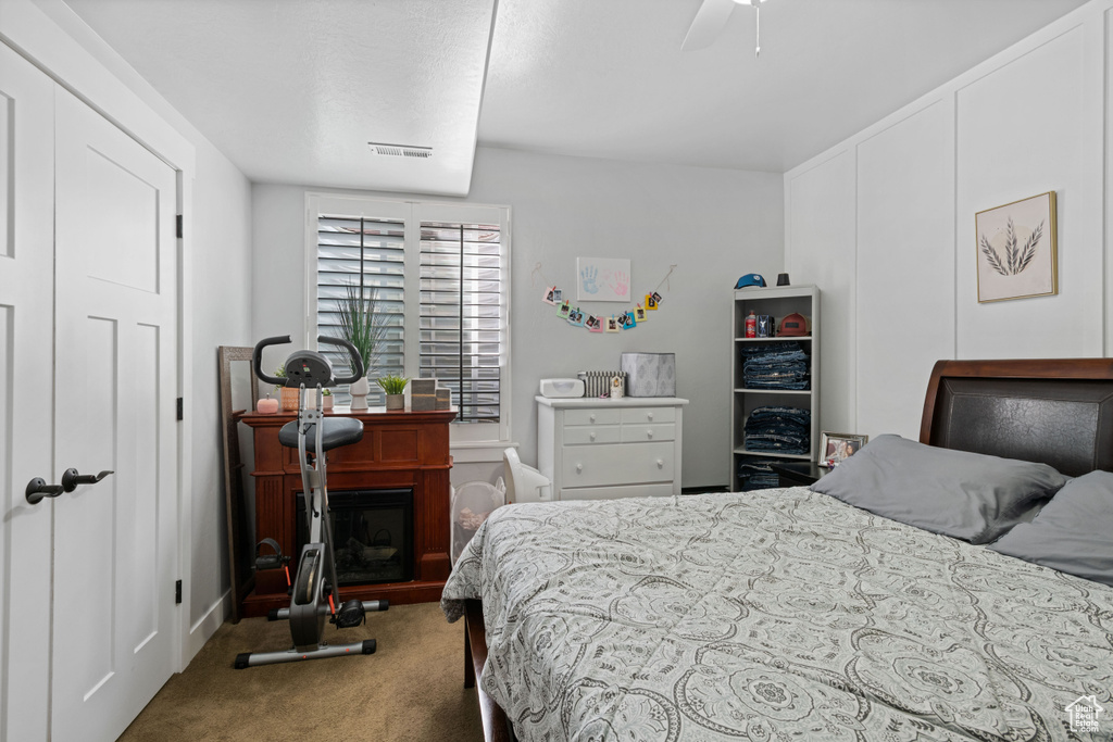 Carpeted bedroom featuring a ceiling fan