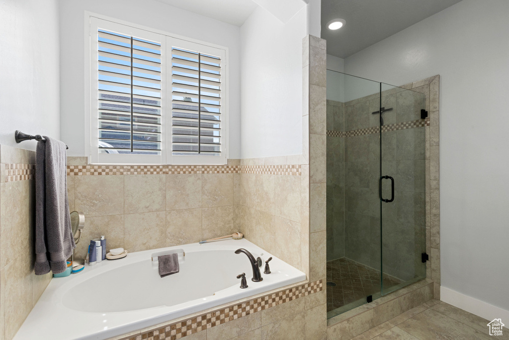 Bathroom featuring a garden tub, a stall shower, and tile patterned floors