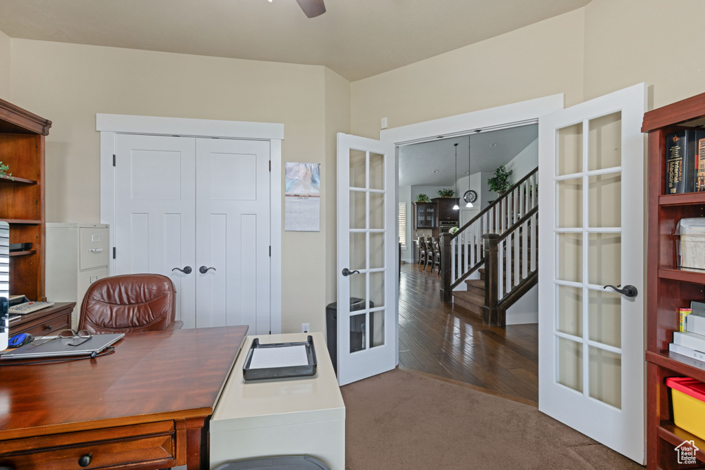 Office with french doors, carpet, ceiling fan, and wood finished floors