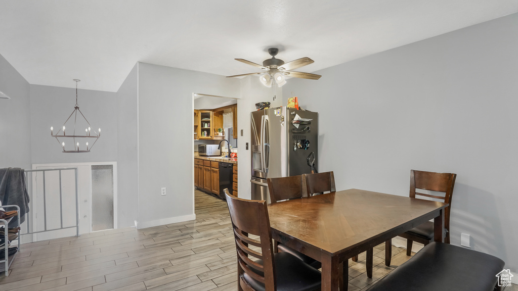 Dining room featuring a chandelier, light wood-type flooring, and a ceiling fan