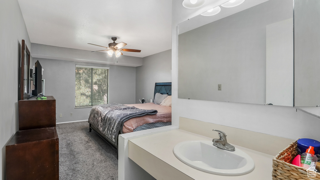 Carpeted bedroom featuring a sink and ceiling fan