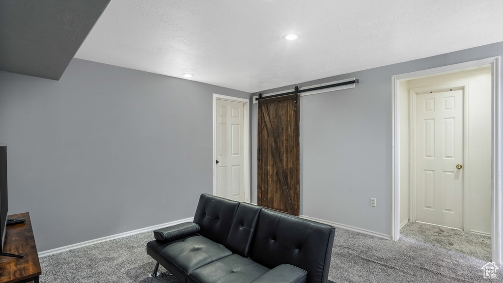 Living area with carpet, a barn door, and recessed lighting