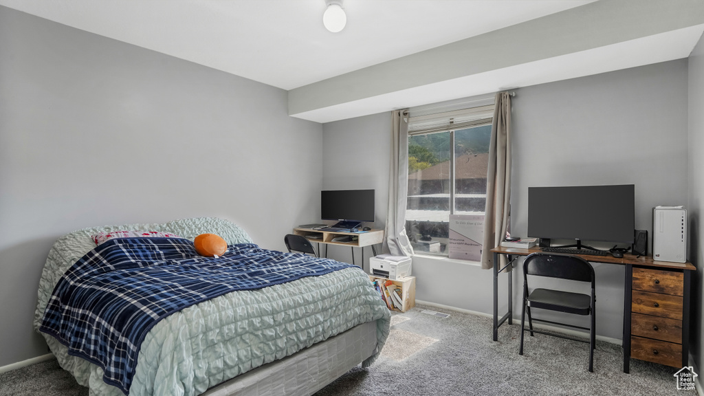 Carpeted bedroom featuring a desk