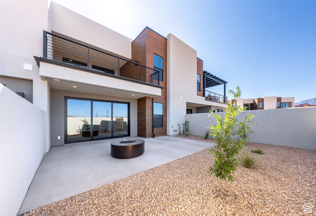 Back of house with a patio, stucco siding, and an outdoor fire pit