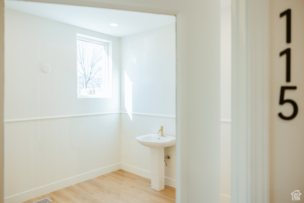 Bathroom with wainscoting and wood finished floors