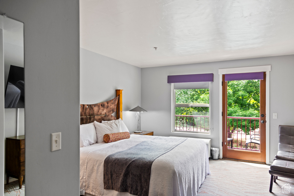 Bedroom featuring access to outside and light colored carpet