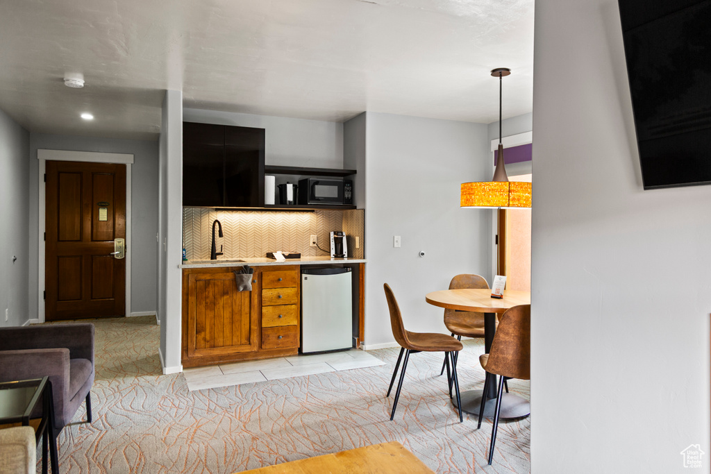 Kitchen with dishwasher, black microwave, light countertops, backsplash, and dark cabinets