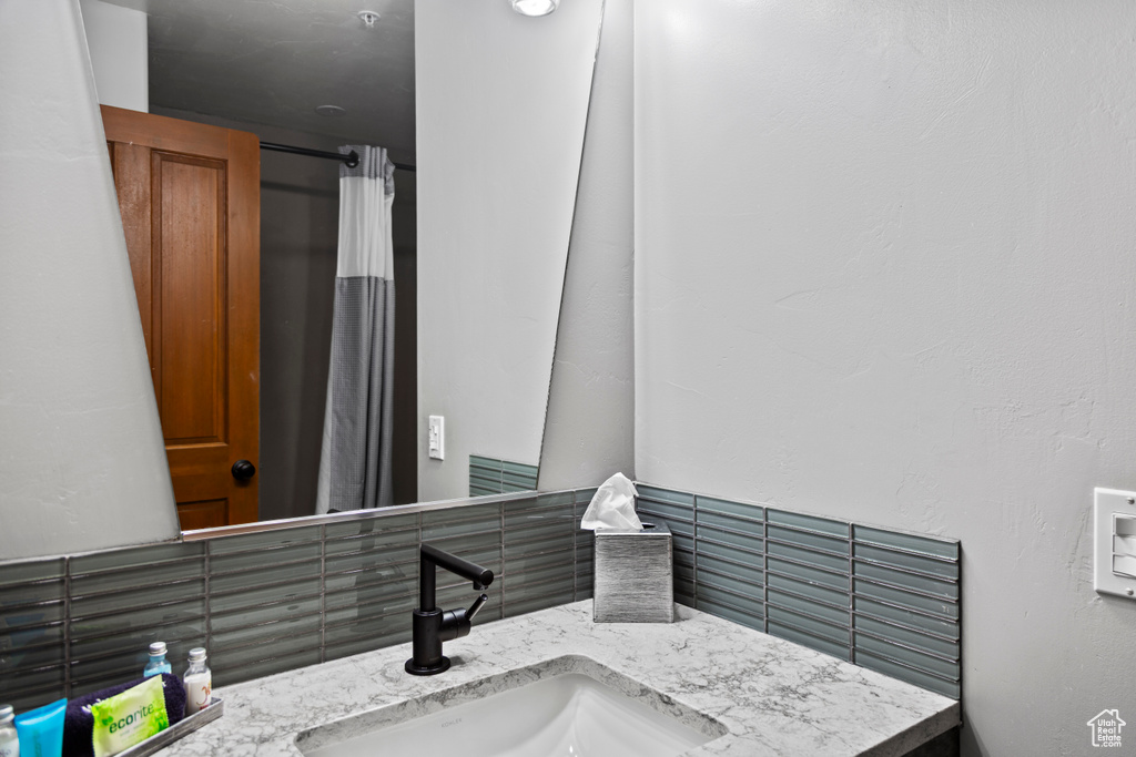 Bathroom with vanity and decorative backsplash