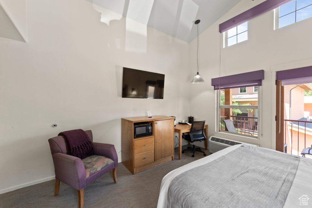 Bedroom with high vaulted ceiling, a desk, carpet floors, and an AC wall unit