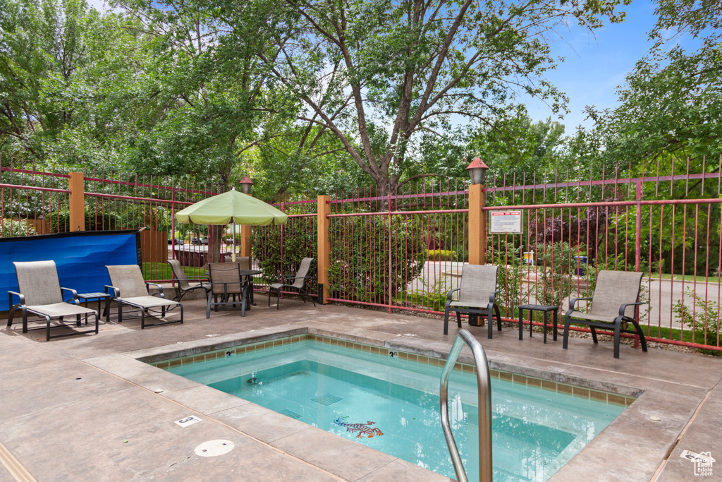 View of swimming pool with a hot tub, a patio, and a swimming pool